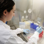 AI Startup Accelerates Disease Research Using Lab Integration woman in a lab coat conducting research