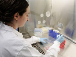 AI Startup Accelerates Disease Research Using Lab Integration woman in a lab coat conducting research