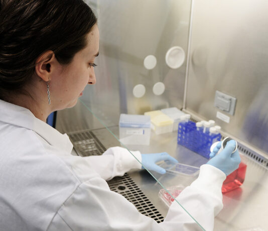 AI Startup Accelerates Disease Research Using Lab Integration woman in a lab coat conducting research