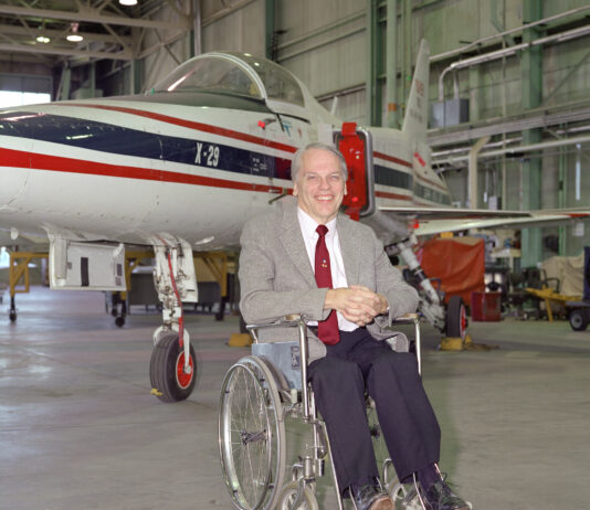 Ken Iliff’s Four-Decade Engineering Legacy at NASA A man sits in a wheelchair with an experimental aircraft in the background.