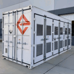 NASA Develops Groundbreaking Battery Through Engineering Innovation A white shipping-container-like enclosure, adorned with the logo for Enervenue, sits next to a building