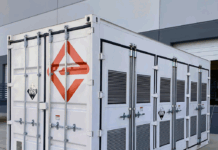 NASA Develops Groundbreaking Battery Through Engineering Innovation A white shipping-container-like enclosure, adorned with the logo for Enervenue, sits next to a building