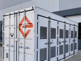 NASA Develops Groundbreaking Battery Through Engineering Innovation A white shipping-container-like enclosure, adorned with the logo for Enervenue, sits next to a building