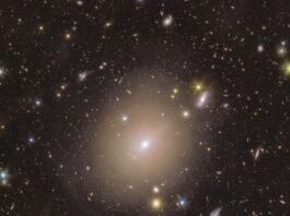 NASA’s Euclid Finds Einstein Ring Near Earth A sea of colorful stars and galaxies appear to swim in the vast blackness of space around a hazy halo at centre stage. In the middle of the image, the fuzzy-looking bulb of light in a warm shade of yellow extends around a small bright spot, nestled within a thin light circle that appears to be drawn closely around it. As we follow the central halo’s rim outwards, its brightness dims and blends smoothly into its surroundings. Here, extended discs of shades ranging from a warm purple to golden yellow, and piercing dots of light with sharp diffraction spikes are spread evenly across the image.