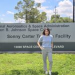 Farah Al Fulfulee: Pursuing Her NASA Dream to the Stars A woman in casual clothes poses in front of a sign for the Johnson Space Center