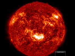 NASA’s Insights from Major Geomagnetic Storm in Two Decades A detailed, fiery image of the Sun showing bright solar flares and textured surface, with a small inset at the bottom right comparing the tiny size of Earth to the massive scale of the Sun.