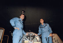 Gemini III: Celebrating 60 Years of Two-Person Spaceflight Two astronauts wearing blue flight suits pose with their space capsule aboard the recovery ship.