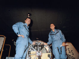 Gemini III: Celebrating 60 Years of Two-Person Spaceflight Two astronauts wearing blue flight suits pose with their space capsule aboard the recovery ship.