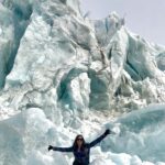 Snow Days Inspired Linette Boisvert’s Journey to Sea Ice Science – NASA Linette Boisvert sits on a large light blue glacier with her arms stretched out to both sides.