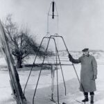 100 years later: NASA marks Goddard’s rocketry breakthrough anniversary. On a snowy March 16, 1926, Dr. Robert H. Goddard rests his hand on the testing frame supporting his liquid fuel rocket at Ward Farm in Auburn, Massachusetts. A wooden door is propped up at an angle next to the frame where Goddard’s assistant, Henry Sachs, later sheltered after lighting the rocket.