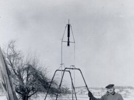 100 years later: NASA marks Goddard’s rocketry breakthrough anniversary. On a snowy March 16, 1926, Dr. Robert H. Goddard rests his hand on the testing frame supporting his liquid fuel rocket at Ward Farm in Auburn, Massachusetts. A wooden door is propped up at an angle next to the frame where Goddard’s assistant, Henry Sachs, later sheltered after lighting the rocket.