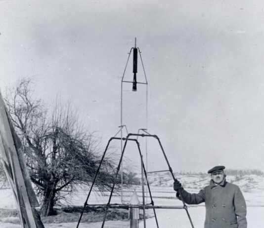 100 years later: NASA marks Goddard’s rocketry breakthrough anniversary. On a snowy March 16, 1926, Dr. Robert H. Goddard rests his hand on the testing frame supporting his liquid fuel rocket at Ward Farm in Auburn, Massachusetts. A wooden door is propped up at an angle next to the frame where Goddard’s assistant, Henry Sachs, later sheltered after lighting the rocket.