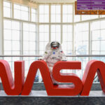 Ohio Space Week Festivities Held by NASA Glenn An astronaut mascot stands behind large red letters spelling out “NASA.”