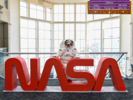Ohio Space Week Festivities Held by NASA Glenn An astronaut mascot stands behind large red letters spelling out “NASA.”