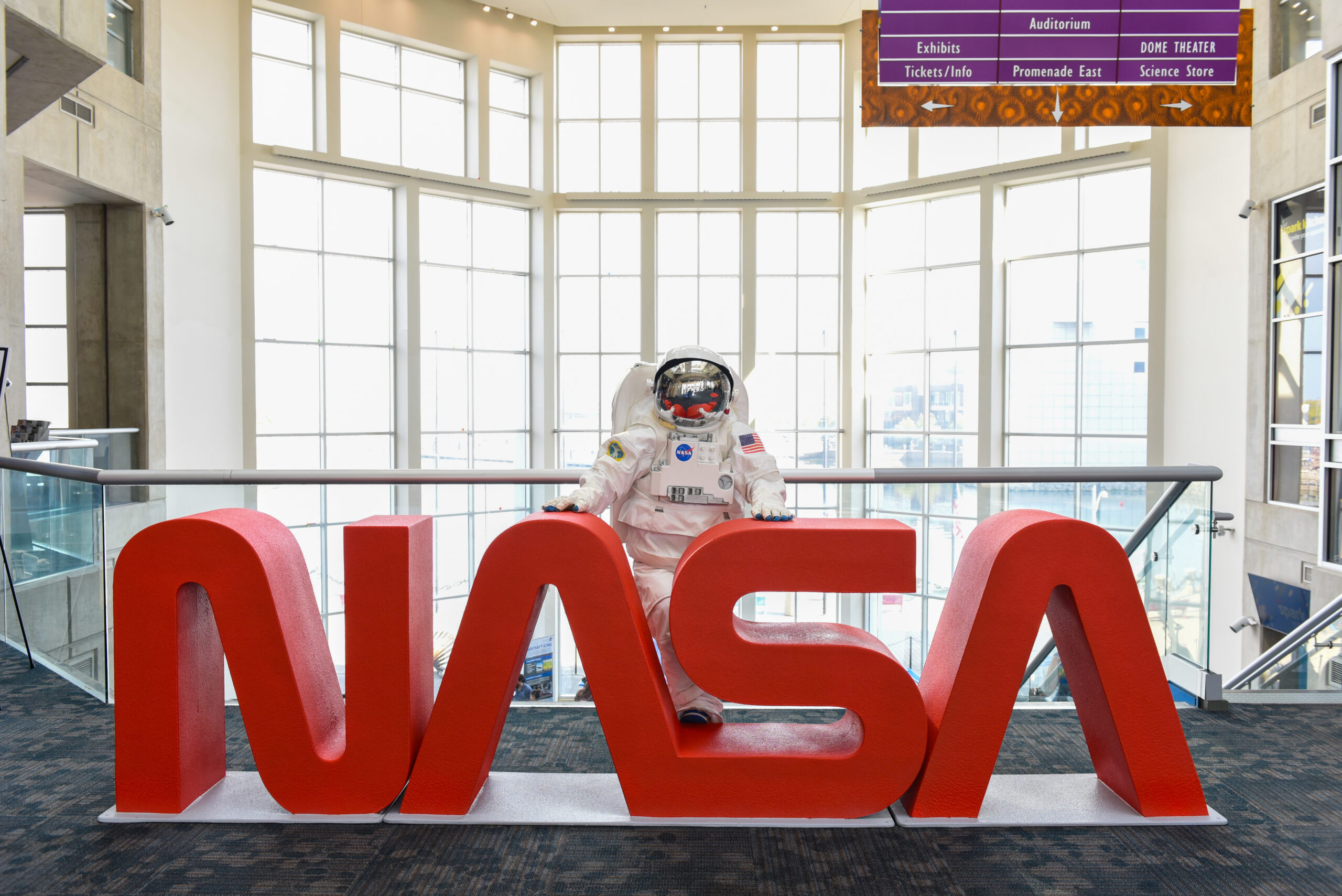 grc 2025 cn 00036.jpg An astronaut mascot stands behind large red letters spelling out “NASA.”