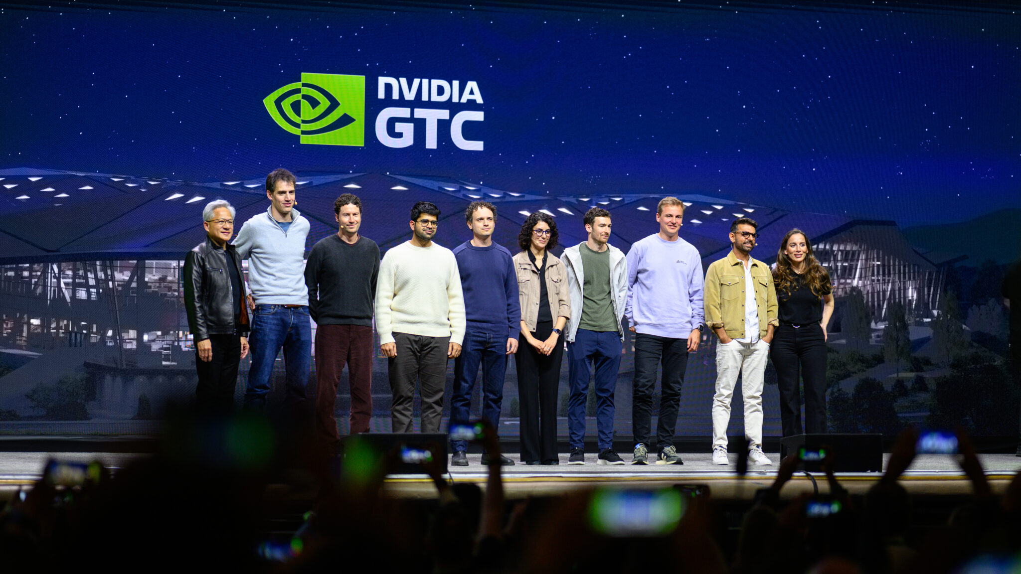 Standing from left to right: Jensen Huang, Arthur Mensch, Daniel Nadler, Aravind Srinivas, Misha Laskin, Hanna Hajishirzi, Harrison Chase, Robin Rombach, Anjney Midha, Mira Murati