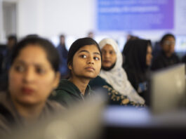 Indians Embrace AI Training for Professional and Personal Growth A group of young women look up from their computer screens.