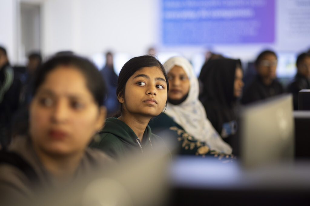hero 1024x683.jpg A group of young women look up from their computer screens.