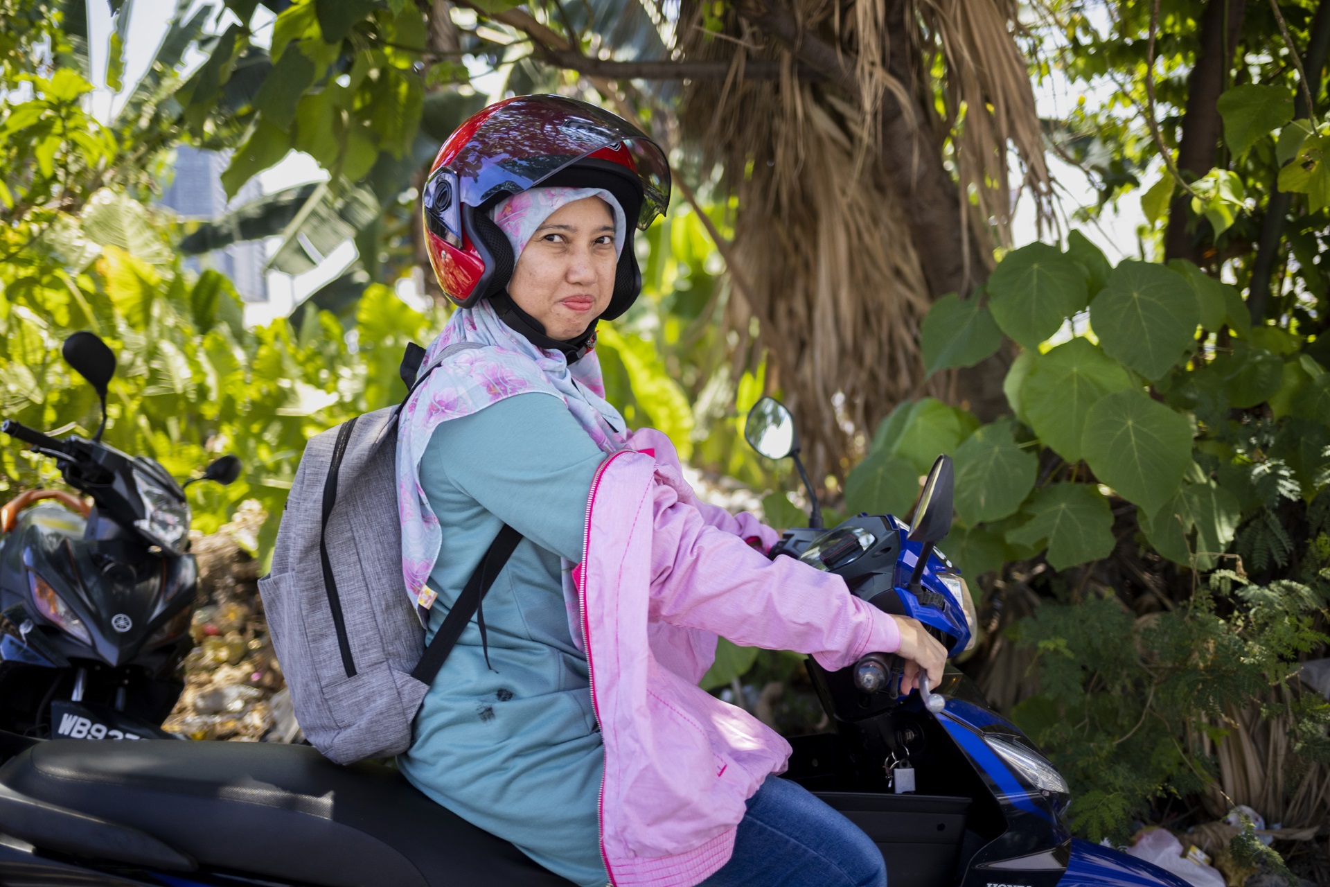 Woman wearing helmet riding a motorbike.