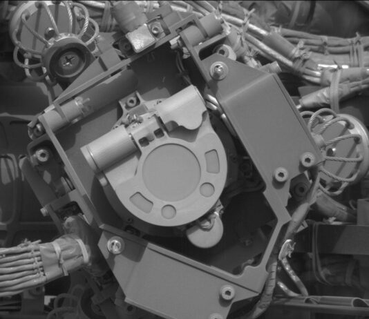 Martian Dust and Magnets: NASA’s Exploration on Sols 4536-4538 A grayscale close-up image of an instrument on the Mars rover Curiosity, showing at the center of the image a U-shaped flat piece of metal face the camera, with its rounded bottom pointing toward the lower right corner of the image. It’s surrounded by metal plates at different angles, some parallel to the plane of the image, others perpendicular, and most of them secured with hex nuts. Braided bunches of cable are twisted behind these other sections, leading into the instrument.