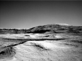 NASA Curiosity: Exploring Martian Atmosphere on Sols 4604-4606 A grayscale photo from the Martian surface shows a landscape of undulating but mostly smooth terrain from the front of the image to a gently sloping hill that rises from the center of the image toward the upper right side of the frame. Beyond that, a straight ridge creates a horizon line along the left side of the image, disappearing from sight behind the hill.