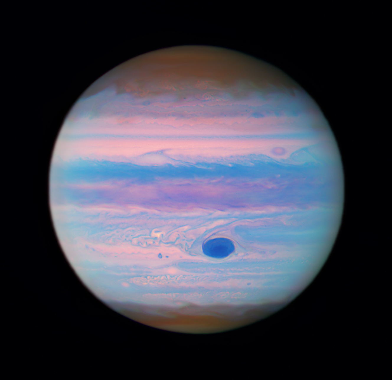 Jupiter looks iridescent in this ultraviolet image from the Hubble Space Telescope. The poles are a muted orange color, while swirls and stripes of pink, orange, blue, and purple cover the rest of the planet. Jupiter