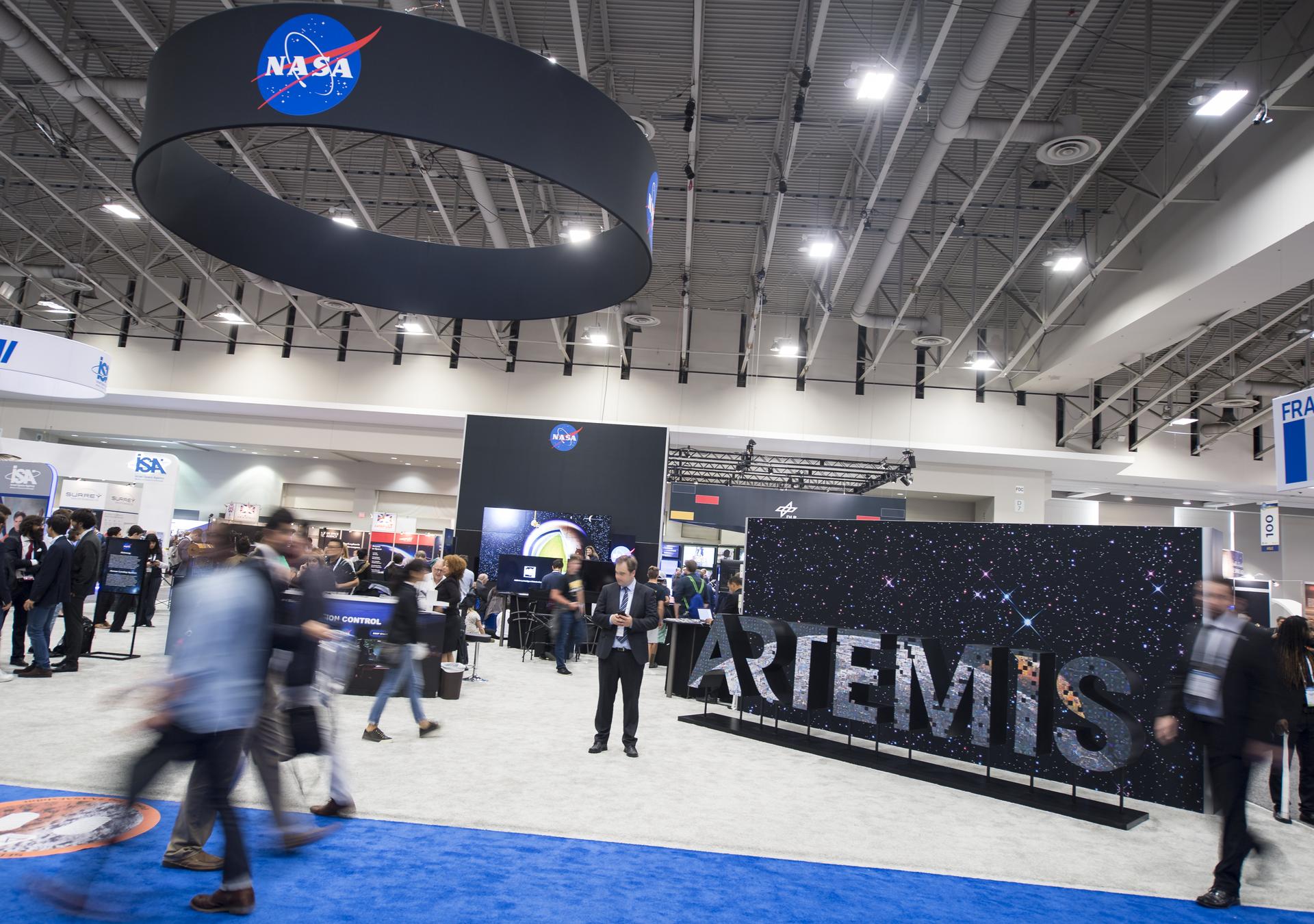 Attendees are seen by the NASA exhibit at the 70th International Astronautical Congress, Friday, Oct. 25, 2019, at the Walter E. Washington Convention Center in Washington.