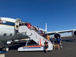Retired DC-8 Aircraft Inspires Students Beyond Textbooks – NASA A group of 22 students pose on a stairway descending from an aircraft door. The plane and stairway are white, on a sunny tarmac.