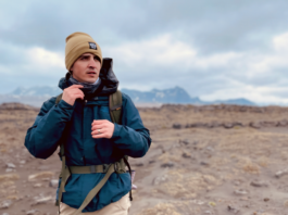 NASA’s Dr. Michael Thorpe: Expert in Sedimentary and Planetary Geology A man wearing a tan beanie and a blue winter jacket with a hiking backpack strapped around him. He