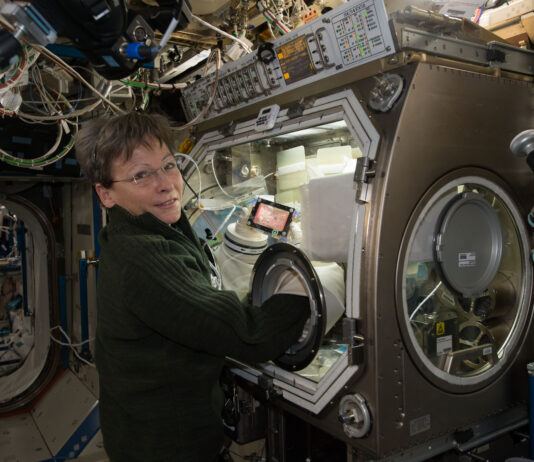 NASA Station Science Highlights: November 8, 2024 An astronaut works with a glovebox experiment aboard the International Space Station. She stands in front of the enclosed equipment, reaching her hands into glove ports to manipulate materials inside the chamber.