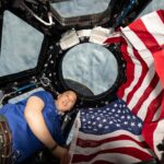 NASA Marks 25 Years of Human Space Exploration NASA astronaut and Expedition 73 Flight Engineer Jonnny Kim poses for a portrait with the American flag on the Fourth of July, or Independence Day, inside the International Space Station