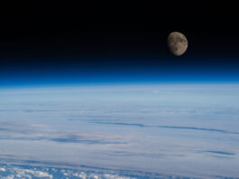 NASA Highlights Waxing Gibbous Moon Phase The Moon is nearly full and a deep gray-brown color in this image. Below it is Earth’s blue atmosphere and and white clouds. This photo was taken from the International Space Station.