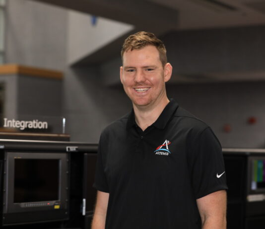 Joe Pavicic: NASA’s Artemis Mission Highlight Image shows man smiling in black shirt with NASA