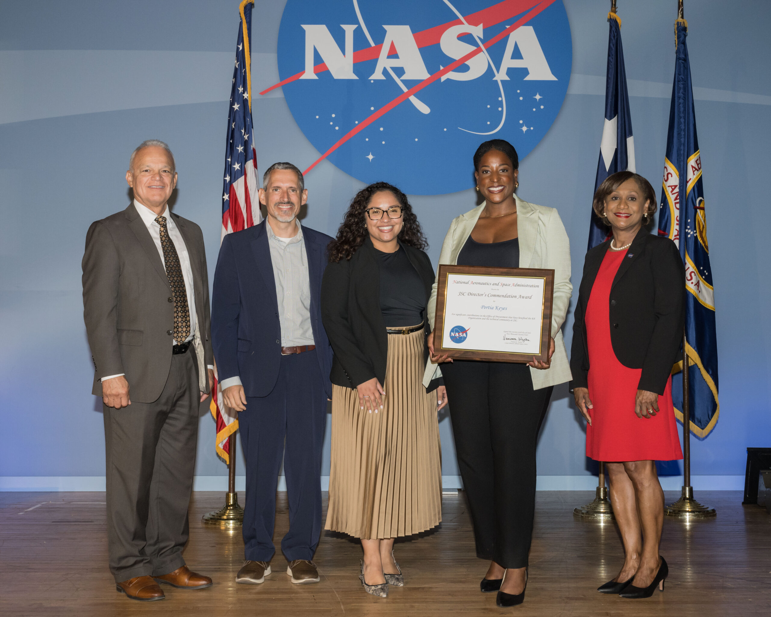 jsc directors commendation award.jpg A NASA employee receives an award from four of her colleagues.