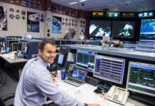 Brian Alpert Leverages Experience for Artemis Moon Mission Success A man wearing a headset sits at a computer console in the Mission Control Center at Johnson Space Center.