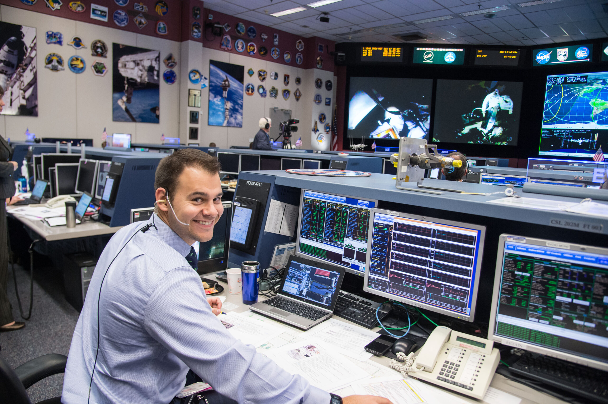 jsc2015e099423.jpg A man wearing a headset sits at a computer console in the Mission Control Center at Johnson Space Center.