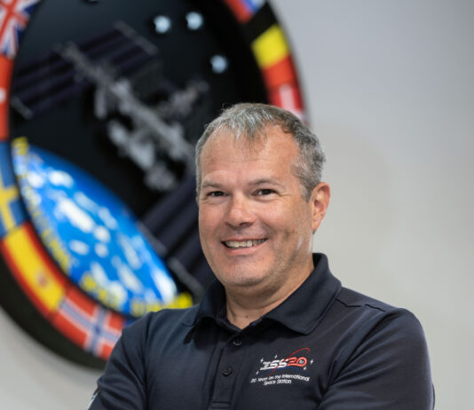 David Korth Appointed Deputy for NASA’s Safety Directorate A white, smiling male in a blue polo stands with arms folded in front of the International Space Station logo.