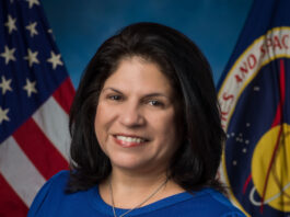 Jennifer Becerra: Pioneering STEM Influence at NASA Johnson A professional portrait of a woman with dark hair, wearing a blue top. She stands in front of the American flag and NASA’s emblem.