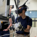 New Astronaut Trainees Begin Duties at NASA’s Johnson Space Center An astronaut wears a VR headset and holds controllers in his hands during a training exercise.