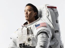 Astronaut Jonny Kim Talks Future Mission and Launch Plans NASA astronaut Jonny Kim looks off-camera, dressed in a white space suit with an American flag on the sleeve.