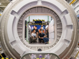 NASA’s Kibo Challenge Revolutionizes Robotics Programming A group of six people pose inside a large circular module in a space station habitat mockup.