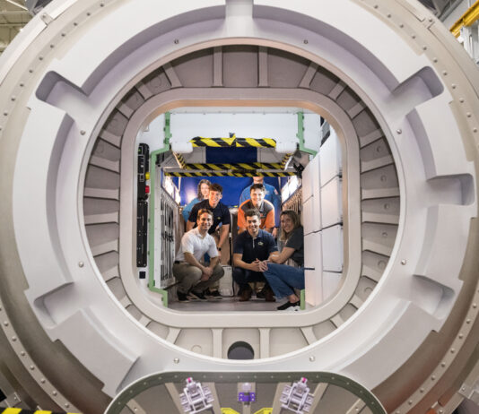 NASA’s Kibo Challenge Revolutionizes Robotics Programming A group of six people pose inside a large circular module in a space station habitat mockup.