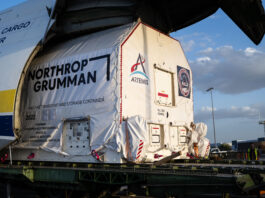 NASA Celebrates Arrival of HALO Module for Lunar Gateway A large cargo aircraft with its nose lifted open reveals a wrapped container being offloaded. The container is marked with the logo for NASA