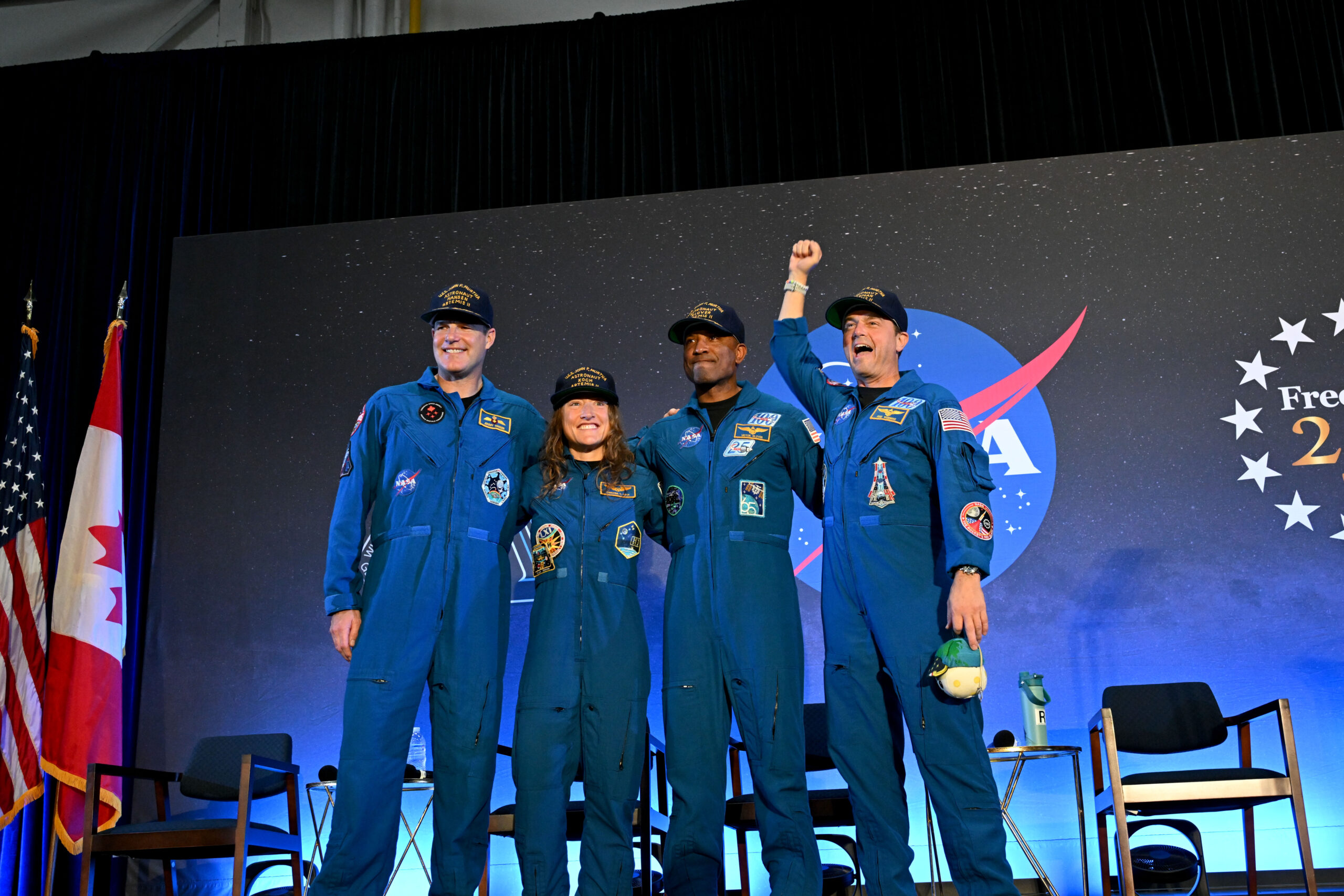 jsc2026e022311orig.jpg CSA (Canadian Space Agency) astronaut Jeremy Hansen and NASA astronauts Reid Wiseman, Victor Glover, and Christina Koch smile at the crowd during a news conference. They are all wearing blue jumpsuits with patches on the arms and chest areas. Wiseman raises his right fist in a victorious pose.