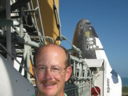 Michael Ciancone Leaves Enduring Impact on Human Spaceflight at NASA A man wearing a neon green polo smiles outside on a sunny day in front of a space shuttle.