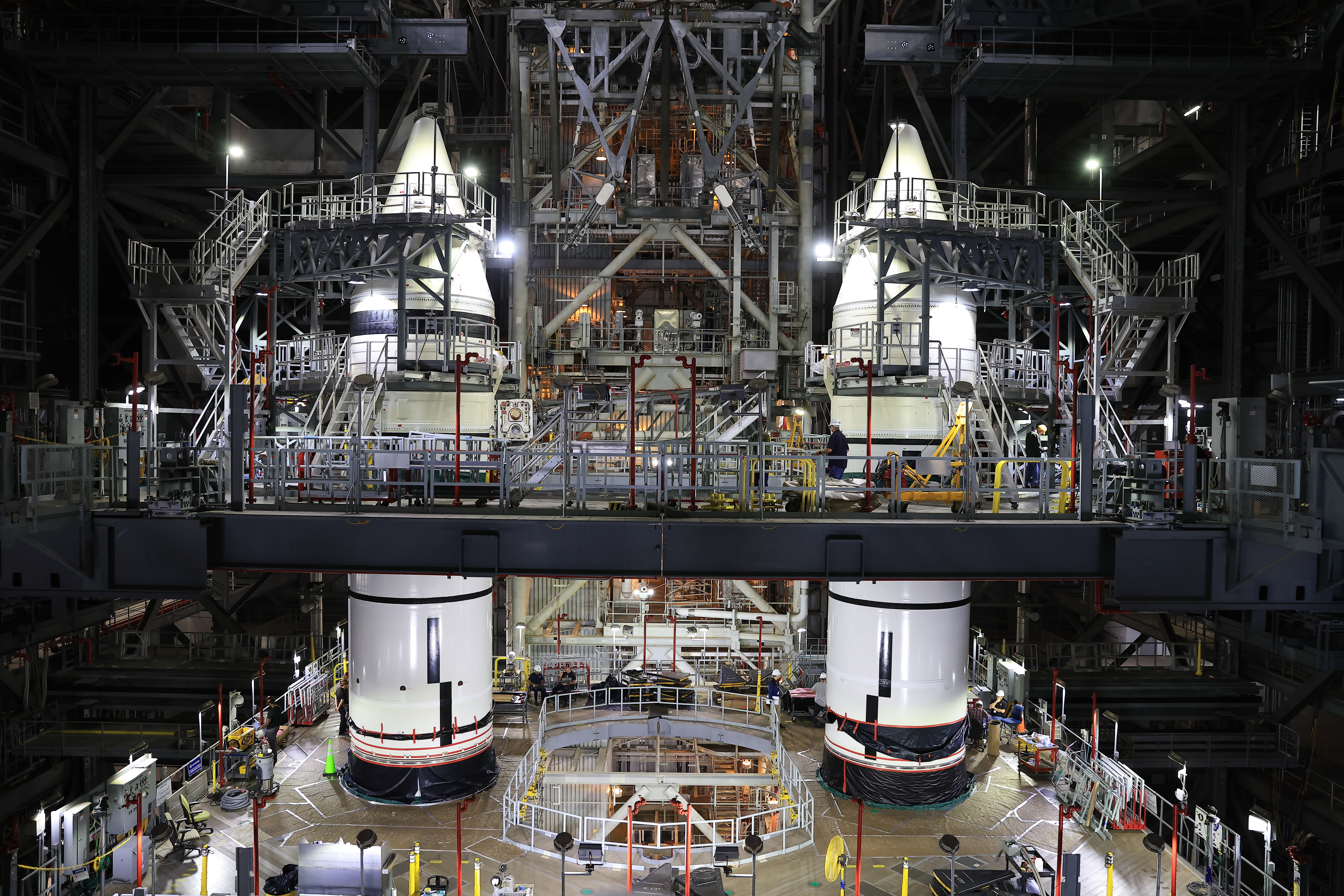 ksc 20250219 ph kls01 0001orig.jpg Two massive white rocket boosters stand inside the Vehicle Assembly Building. There are balconies and stairs around the boosters, reaching all the way up to the recently integrated nose cones.