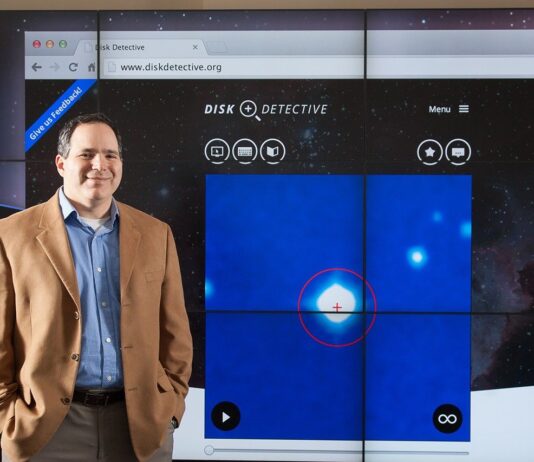 Join NASA’s Citizen Science Projects: A Guide Photo of a man standing next to a large projected image of the Disk Detective website