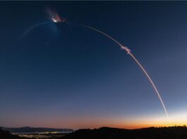 Firefly Aerospace Launches Eight NASA CubeSats into Space! A photo taken with extended exposure shows the streak of light made by a rocket in a twilight sky. City lights are below on the left and the horizon has an orange glow where the sun has set in the lower right.