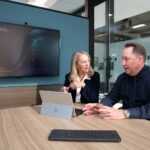 Copilot’s unique assistance to major Canadian credit union A man and a woman sit at a table in a conference room working on a Surface tablet