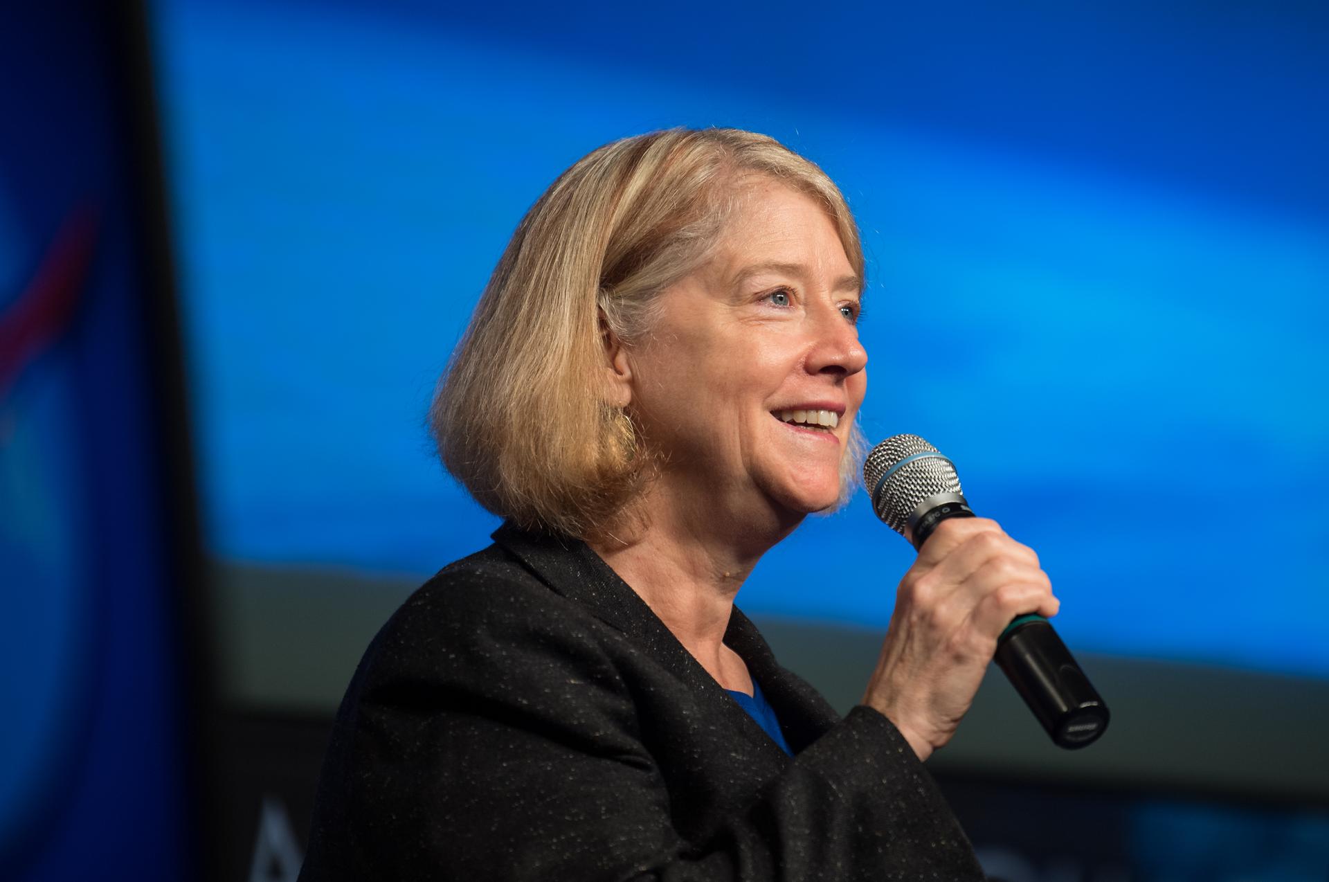 nhq202109210007large.jpg NASA Deputy Administrator Pam Melroy smiles as she speaks into a microphone at an employee town hall, with a blue background behind her.